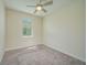 Bedroom featuring neutral walls, plush carpeting, a ceiling fan, and a large window for ample natural light at 2733 Attwater Loop, Winter Haven, FL 33884