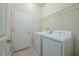 Laundry room featuring a washer, a dryer, wire shelving, tile floors, and a door to the left at 2733 Attwater Loop, Winter Haven, FL 33884