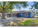 Back exterior view of home featuring a large screened-in patio, big tree, and a well-maintained yard at 275 Cherry Laurel Ln, Winter Haven, FL 33880