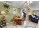 A dining area with a wooden table, chairs, hanging plants, and view to the living room at 275 Cherry Laurel Ln, Winter Haven, FL 33880