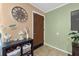A cozy entryway with tan and green walls features a decorative wall clock and a functional storage shelf at 275 Cherry Laurel Ln, Winter Haven, FL 33880