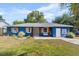 Charming blue home featuring a well-maintained lawn, wood shutters, and a welcoming front porch area at 275 Cherry Laurel Ln, Winter Haven, FL 33880