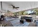 A large, covered patio featuring multiple seating areas, ceiling fans, and views of the backyard at 275 Cherry Laurel Ln, Winter Haven, FL 33880