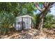 Backyard shed surrounded by greenery and trees providing additional storage for outdoor tools at 275 Cherry Laurel Ln, Winter Haven, FL 33880