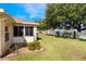 Well-maintained backyard with green grass and a view of the house and sunroom addition at 284 Lake Suzanne Dr, Lake Wales, FL 33859