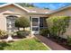 Inviting front entrance features lush landscaping, a charming fountain, and a brick walkway leading to the screened porch at 284 Lake Suzanne Dr, Lake Wales, FL 33859