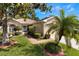 Charming home exterior with a well-manicured front yard, palm tree, and lush landscaping at 284 Lake Suzanne Dr, Lake Wales, FL 33859