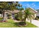 Charming home featuring well-manicured landscaping, mature trees and a brick walkway leading to a screened front entrance at 284 Lake Suzanne Dr, Lake Wales, FL 33859