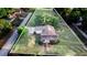 Aerial view of a home featuring a well-maintained lawn, mature trees, and a paved driveway at 302 W Gates Ave, Lake Hamilton, FL 33851