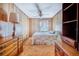 The bedroom features warm wood paneling, a floral bedspread, a ceiling fan, and ample storage space at 302 W Gates Ave, Lake Hamilton, FL 33851