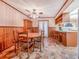 Eat-in dining area features wood floors, wainscoting, and ceiling fan, adjacent to kitchen with bar seating at 302 W Gates Ave, Lake Hamilton, FL 33851
