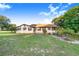 Charming one-story home featuring symmetrical design, white siding, and beautiful mature trees and landscaping at 302 W Gates Ave, Lake Hamilton, FL 33851