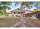 Charming two-story home with a covered porch, wooden accents, and a spacious yard shaded by trees at 302 W Gates Ave, Lake Hamilton, FL 33851