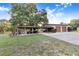 Exterior view of home with covered parking area, two-car garage and a well-maintained yard at 302 W Gates Ave, Lake Hamilton, FL 33851