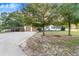 Inviting home exterior with a long driveway, two-car garage, covered parking, and mature landscaping at 302 W Gates Ave, Lake Hamilton, FL 33851