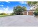 Features of the property include a large concrete parking area, a two-car garage, and a carport at 302 W Gates Ave, Lake Hamilton, FL 33851