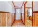 Traditional hallway with wood paneling and textured wallpaper, adjacent to a room with a window at 302 W Gates Ave, Lake Hamilton, FL 33851