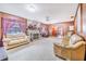The living room features a stone fireplace, wood paneling, two couches, and a view into the dining room at 302 W Gates Ave, Lake Hamilton, FL 33851