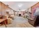 A spacious living room with wood paneling, stone fireplace, multiple seating areas, and a ceiling fan at 302 W Gates Ave, Lake Hamilton, FL 33851
