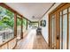 Long open porch featuring tile floors, seating, and wood pillars at 302 W Gates Ave, Lake Hamilton, FL 33851