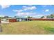 View of the back of the home, including a covered patio and spacious fenced-in yard at 317 Oak Trl, Lakeland, FL 33813