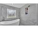 Luxurious bathroom features a stylish glass shower, decorative window, and soaking tub at 317 Oak Trl, Lakeland, FL 33813