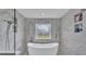 Luxurious bathroom features a soaking tub, decorative window, marble tiling and recessed shelving at 317 Oak Trl, Lakeland, FL 33813