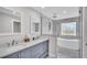 Bright bathroom features a glass shower, soaking tub, and double sink vanity with gray cabinetry at 317 Oak Trl, Lakeland, FL 33813