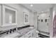 Modern bathroom features double sinks, granite countertops, and a walk-in shower with glass doors at 317 Oak Trl, Lakeland, FL 33813