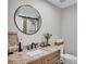 Beautiful bathroom vanity featuring granite counter tops, a round mirror, and glass enclosed shower at 317 Oak Trl, Lakeland, FL 33813