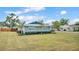 A quaint home boasting a freshly painted exterior, a blue metal roof, and manicured landscaping for an inviting curb appeal at 317 Oak Trl, Lakeland, FL 33813