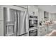 Stainless steel appliances include refrigerator and double ovens surrounded by bright cabinets and granite countertops at 317 Oak Trl, Lakeland, FL 33813