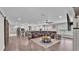 Spacious open-concept living room with wood floors, barn door, fireplace, and a large leather couch at 317 Oak Trl, Lakeland, FL 33813