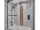 Beautiful shower with marble tiles, glass door, and built in shower products container at 317 Oak Trl, Lakeland, FL 33813