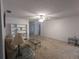 Spacious living room with carpet flooring, a ceiling fan, built-in shelving, and ample natural light at 32 Cedar Dr, Davenport, FL 33837