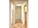 Hallway featuring neutral paint, decorative niche, tile flooring, and access to the kitchen and laundry room at 3430 Hilson Dr, Lakeland, FL 33812