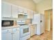 Kitchen featuring white appliances, ample cabinetry, and tile flooring at 3430 Hilson Dr, Lakeland, FL 33812