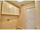 Laundry room featuring white cabinets, beige paint, and tile flooring at 3430 Hilson Dr, Lakeland, FL 33812