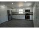 Bright kitchen with white cabinets, stainless steel appliances, and durable gray wood-look flooring at 3434 Avenue E Nw, Winter Haven, FL 33880