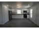 Bright kitchen with white cabinets, stainless steel appliances, and durable gray wood-look flooring at 3434 Avenue E Nw, Winter Haven, FL 33880