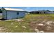 Spacious backyard with a storage shed, partial grass, and a distant view of the screened in pool at 351 Columbo St, Winter Haven, FL 33880
