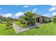 Spacious backyard featuring lush greenery, mature trees, a gravel path, and a covered patio at 364 Lake Vista Dr, Auburndale, FL 33823