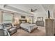 Well lit bedroom with tray ceiling, ceiling fan, and windows with natural light and comfortable furniture and decor at 364 Lake Vista Dr, Auburndale, FL 33823
