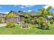 Beautiful home exterior with a well-manicured lawn, mature palm trees, and lovely landscaping at 364 Lake Vista Dr, Auburndale, FL 33823