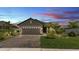 Home exterior at dusk, featuring a brick driveway, well-lit landscaping, and a two-car garage at 364 Lake Vista Dr, Auburndale, FL 33823