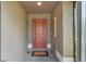 Inviting entryway features a stylish red door, neutral walls, and a charming welcome mat at 364 Lake Vista Dr, Auburndale, FL 33823