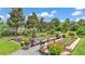 Lush backyard garden with raised beds, potted plants, decorative gravel, and mature trees at 364 Lake Vista Dr, Auburndale, FL 33823