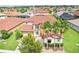 An aerial view of a stunning home with a red tile roof, surrounded by lush landscaping and palm trees at 3833 Bowfin Trl, Kissimmee, FL 34746