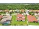 Wide aerial view showcasing a home with a red tile roof and large backyard in a neighborhood with lush greenery at 3833 Bowfin Trl, Kissimmee, FL 34746