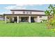 Expansive backyard featuring lush green grass, a covered patio, and a well-maintained lawn at 3833 Bowfin Trl, Kissimmee, FL 34746